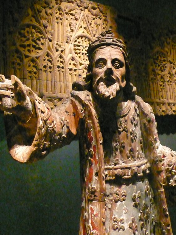 Medieval wooden sculpture of a bearded man with his hand outstretched toward the viewer in the National Museum of Iceland
