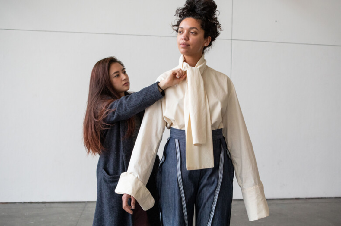 Kim Xuan Pham (BFA 2019) adjusting white shirt on model.